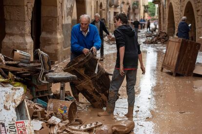 Varios operarios y vecinos realizan tareas de desescombro y limpieza en L'Albi (Lleida) una población que ha resultado gravemente afectada por las lluvias torrenciales, este martes.