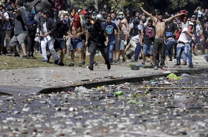 Dezenas de manifestantes lançaram pedras e bombas de efeito moral contra policiais que resistiram durante mais de uma hora atrás de seus escudos de acrílico antes de responder com bombas de gás e bolas de borracha.