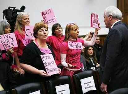 El consejero delegado de AIG, Edward Liddy, ante unas mujeres que protestaban por las primas poco antes de que interviniera en el Congreso.