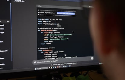 A user sits in front of a screen while the ChatGPT AI program writes AI-powered code.