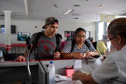 Triztan Rodríguez y su madre, Griselda González, compran un billete para su viaje de 14 horas en carretera hasta Caracas. "(Triztan) Vivía deprimido, llegó a decirme que se quería morir", relata Griselda sobre su hijo, con quien migró a la capital.