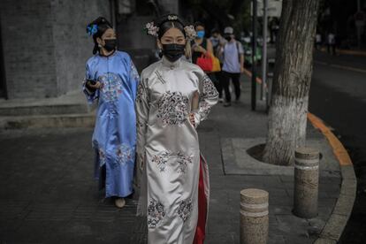 Dos mujeres con vestimenta de la dinastía Qing caminan por la calle en Pekín (China).