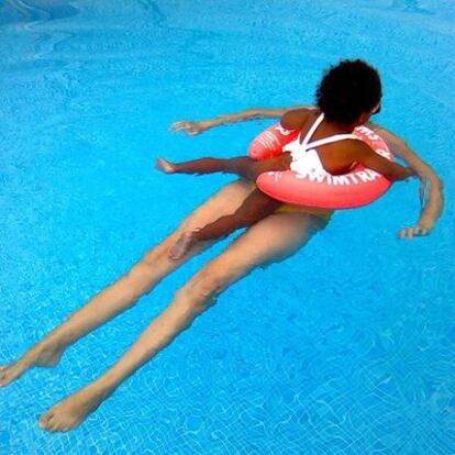 La menor juega en la piscina con su madre adoptiva.