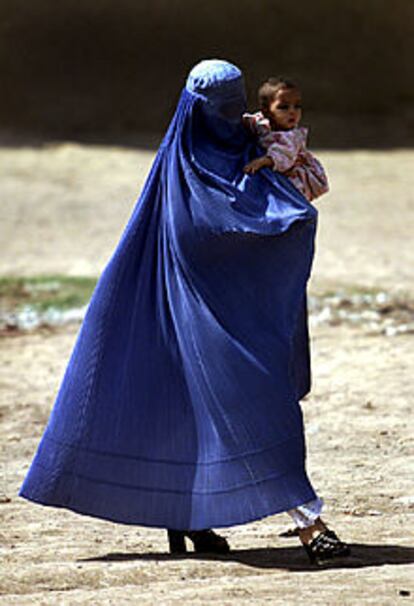 Una mujer afgana pasea con su hija en brazos, en Afganistán.