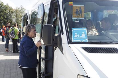 Una mujer compra el billete en un bus de transporte escolar de un municipio de Ourense.