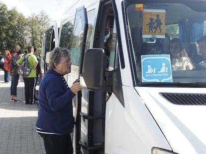 Una mujer compra el billete en un bus de transporte escolar de un municipio de Ourense.
