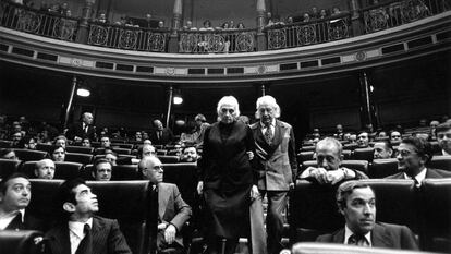 Dolores Ibárruri, 'Pasionaria', y el escritor Rafael Alberti bajan del brazo por las escaleras del Congreso de los Diputados, en la constitución de las primeras cortes democráticas tras las elecciones del 15 de junio.