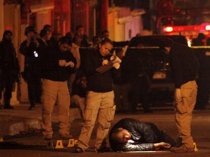 Personal forense mexicano, junto al cadáver de un hombre asesinado en Ciudad Juárez el martes.