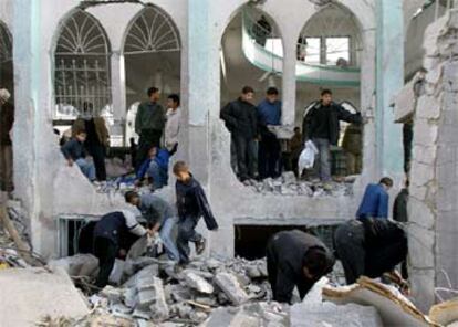 Unos jóvenes caminan entre las ruinas de una mezquita en la franja de Gaza.