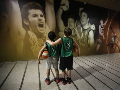 Dos nens davant un panell en les instal·lacions del Joventut en el qual apareixen Rudy Fernández, Rafa Jofresa i Jordi Villacampa.