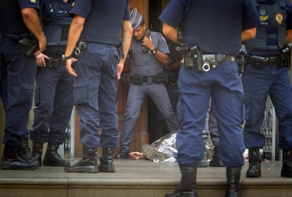 Oficiales de policía rodean el cuerpo de una de las víctimas mortales, en la entrada de la iglesia de Campina.  