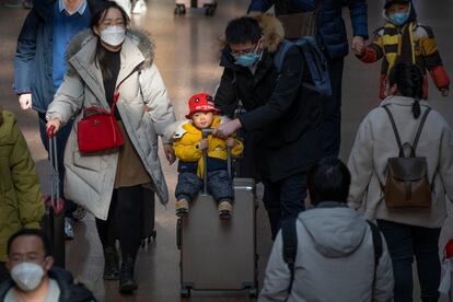 Un hombre empujaba una maleta con un niño agarrado al asa, en una estación de Pekín el pasado miércoles.