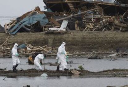 Miembros de los servicios de rescate buscan cadáveres de las personas desaparecidas en la ciudad de Futaba, a espaldas de la central nuclear de Fukushima, en la prefectura de Fukushima (Japón), el pasado 18 de abril.