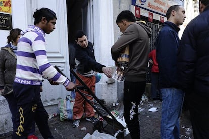 Un grupo de ciudadanos coge mercancía de una tienda destrozada durante los disturbios nocturnos en Túnez, que se han concentrado sobre todo en los suburbios de la capital. El día de hoy ha amanecido más tranquilo en el centro de la ciudad, con las tiendas cerradas y patrullas militares en las calles.