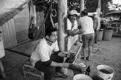 Pescadores en el puerto esperan a que amaine el tiempo para poder salir a ganarse el sustento del día.