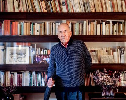 Joan Margarit, en su casa de Barcelona, con sus libros y algunos dibujos y fotografías suyas entre las baldas.