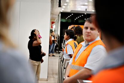 Personal de atención de la estación de Sants en Barcelona trata de dar respuesta a los viajeros afectados por la interrupción del servicio, este viernes.