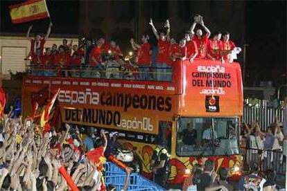 Los campeones del mundo saludan a la multitud desde la terraza de su autobús.