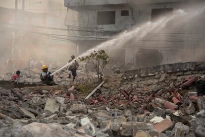 Firefighters put out a fire after a powerful explosion in San Cristobal, Dominican Republic, Monday, Aug 14, 2023