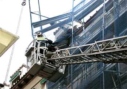 Los bomberos rescatan a los dos obreros que quedaron atrapados tras venirse abajo el andamio en el que trabajaban, en el distrito de Centro.