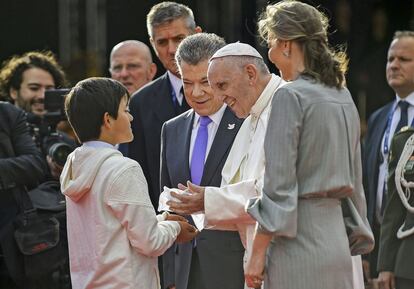 El papa Francisco (centro), acompañado del presidente de Colombia, Juan Manuel Santos, y de la primera dama de la Nación, María Clemencia de Santos, saluda al niño Emmanuel, hijo de la exsecuestrada Clara Rojas a su llegada a la base aérea de Catam.