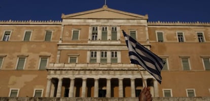 05/07/2016. Un manifestante levanta una bandera de Grecia en una protesta antigobierno en el primer aniversario de las votaciones griegas para un referendo