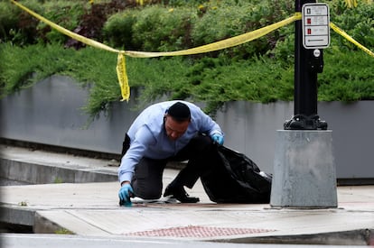 Un hombre que porta un kipá, el gorro ritual judío, limpia la sangre del suelo tras el ataque que ha acabado con la vida de dos empleados de la Embajada israelí en Washington.