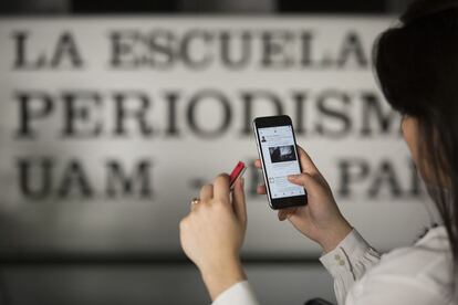 Una joven utiliza el móvil en las instalaciones de la Escuela de Periodismo.