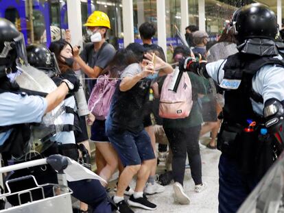 La policía rocía con gas pimienta a los manifestantes.