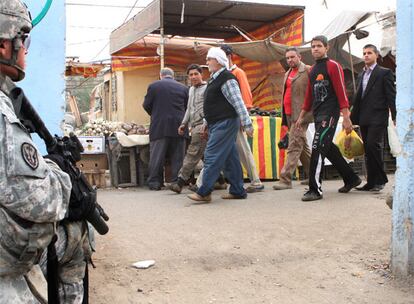 En el mercado de Jamala, el más importante de Ciudad Sáder, los vendedores apenas miran a las tropas estadounidenses, que rodilla en tierra y arma en el hombro vigilan los edificios colindantes.