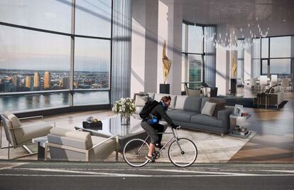 Un ciclista pasa por delante de un anuncio publicitario de pisos de lujo en la ciudad de Nueva York (EE UU).