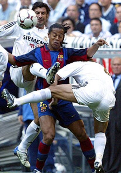 Ronaldinho intenta un control entre Figo y Michel Salgado.