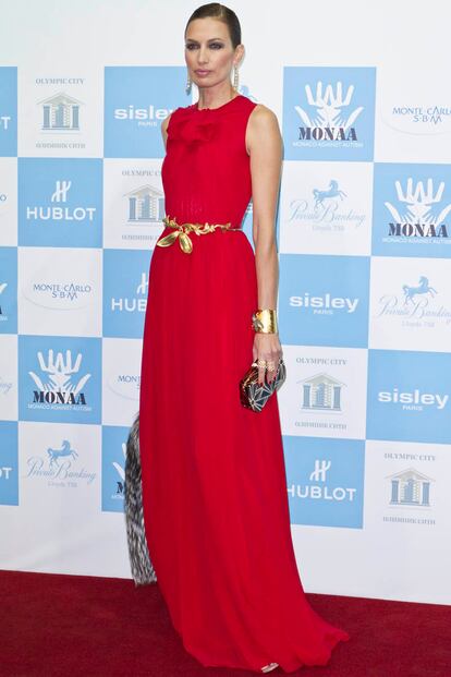Nieves Álvarez asistió con un vestido rojo a un evento de la alta sociedad española. La clave de su elegante look son sus complementos: cinturón de bronce con lazo y brazalete.