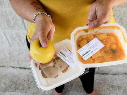 Josefa Labrada posa con el menú repartido por la Comunidad de Madrid en una escuela primaria en el barrio de La Peseta en Madrid.