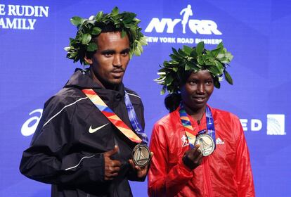 Ghirmay Ghebreslassie, ganador masculino y Mary Keitany, primera en categoría femenina, posan juntos tras el maratón de Nueva York.