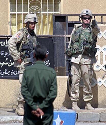 Un hombre mira a dos soldados estadounidenses ayer en Faluya.