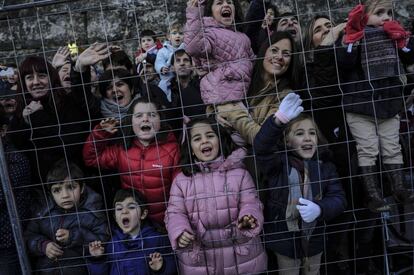 Padres y niños miran con ilusión el paso de las carrozas en Pamplona.