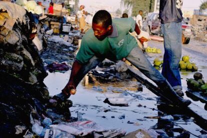 Un hombre recoge una cebolla del suelo en el centro de Puerto Príncipe.