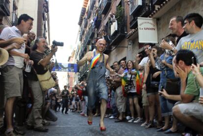 Uno de los participantes en la carrera de tacones de ayer recorre la calle de Pelayo jaleado por el público.