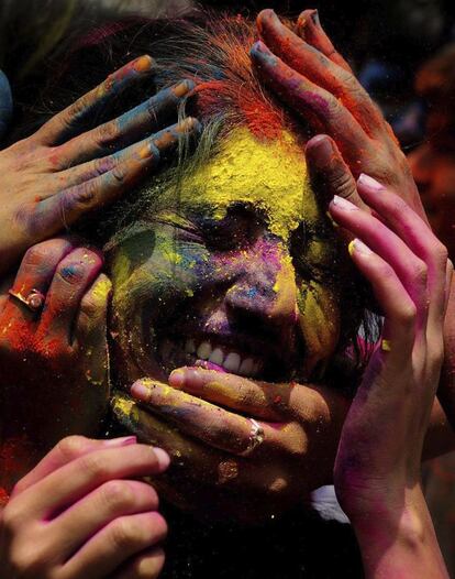 Jóvenes se untan con pigmentos de colores mientras participan en el festival Holi o la celebración hindú del equinoccio de primavera, en Bangalore, India, 27 de marzo de 2013.