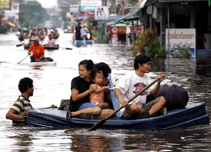Vecinos de Rangsit, en las afueras de Bangkok, intentan ponerse a salvo de las inundaciones.