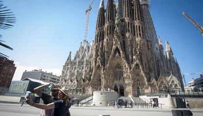 Una parella es fa una foto davant la Sagrada Família, aquest diumenge.