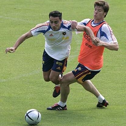 Xavi intenta escaparse de Xabi Alonso en el entrenamiento de ayer.