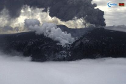 El volcán islandés continua expulsando una gran columna de humo y ceniza. Esta imagen está tomada hoy, a las 12.45, de  una de las <i>webcams</i> que una empresa islandesa ha colocado apuntando al cráter.