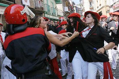 Una defensora del alarde tradicional (a la izquierda) agarra de la solapa a una integrante de una compañía mixta ante la presencia de la Ertzaintza.