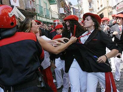 Una defensora del alarde tradicional (a la izquierda) agarra de la solapa a una integrante de una compañía mixta ante la presencia de la Ertzaintza.
