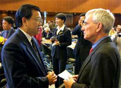 Long Yongtu, jefe de la delegación china ante la OMC, conversa ayer con el representante suizo, Pierre Louis Girard.