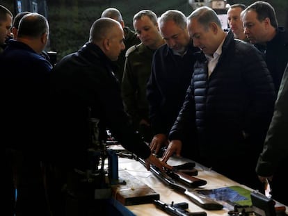 El primer ministro israel&iacute;, Benjam&iacute;n Netanyahu (c), observa una muestra de armas confiscadas en Cisjordania, este martes. 