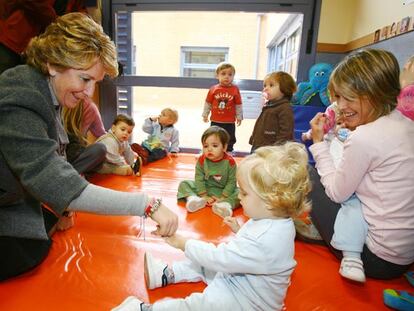 Esperanza Aguirre juega con una niña de la guardería Sol Solito, financiada por la Comunidad de Madrid.