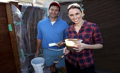 Ardern e seu marido pintam a cerca de sua casa.